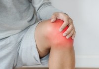 a man touching knee with red highlights concept of knee and joint pain