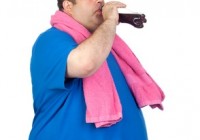Fat man in the gym drinking cola